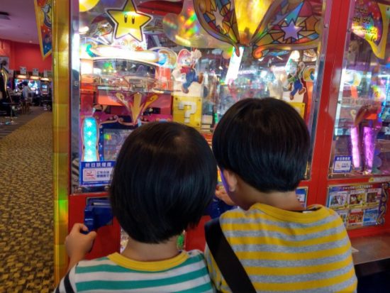 ゲームセンターのマリオゲームで遊ぶ子供たち